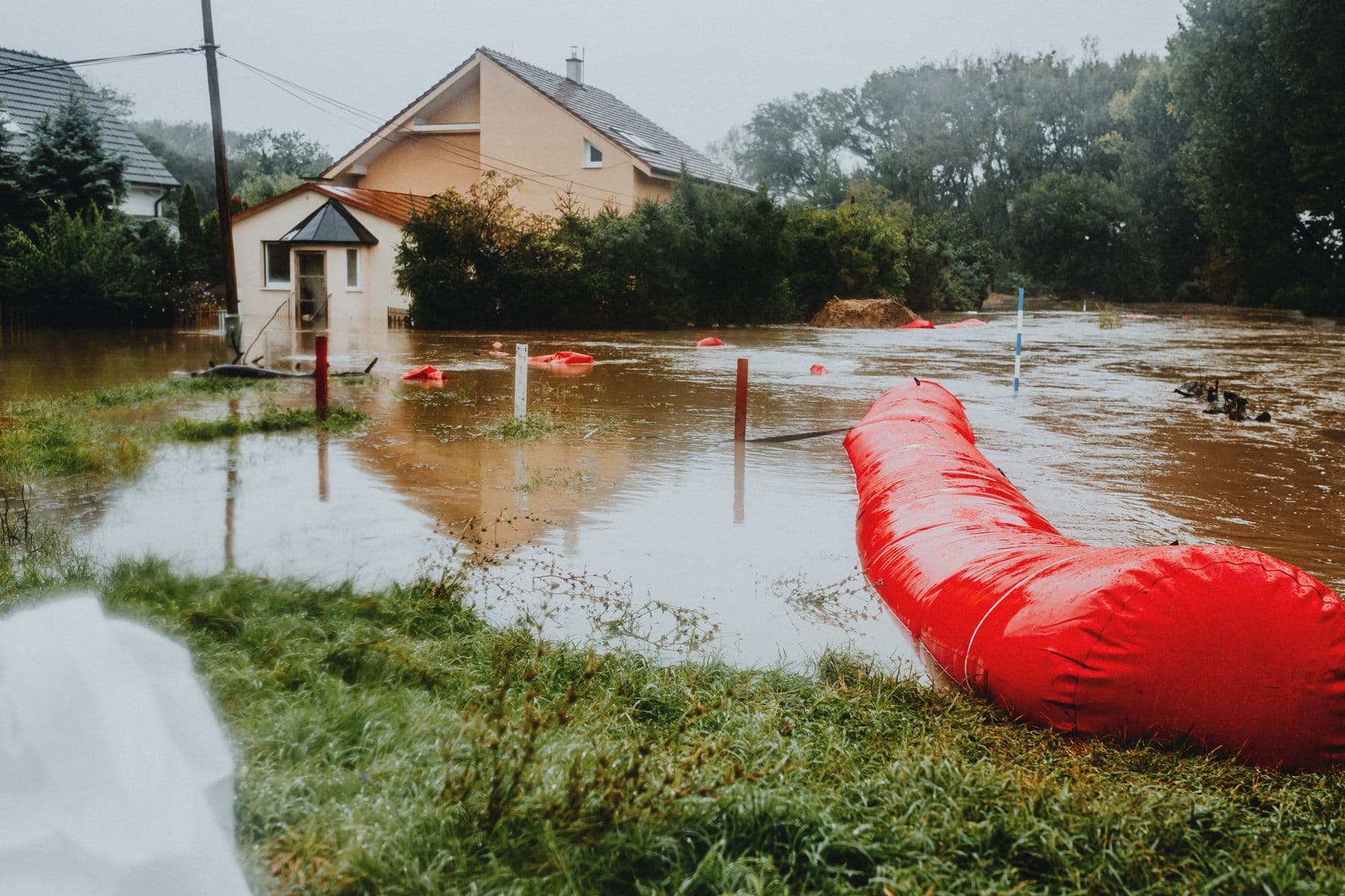 Floodwater rising around a home, held back by an emergency flood barrier