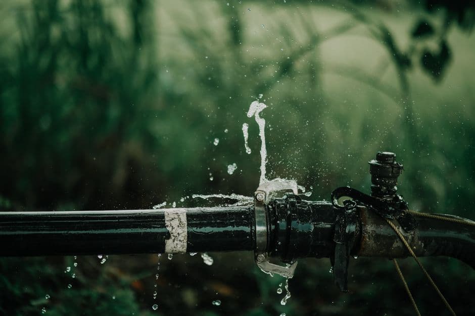 A pipe with water dripping from a joint
